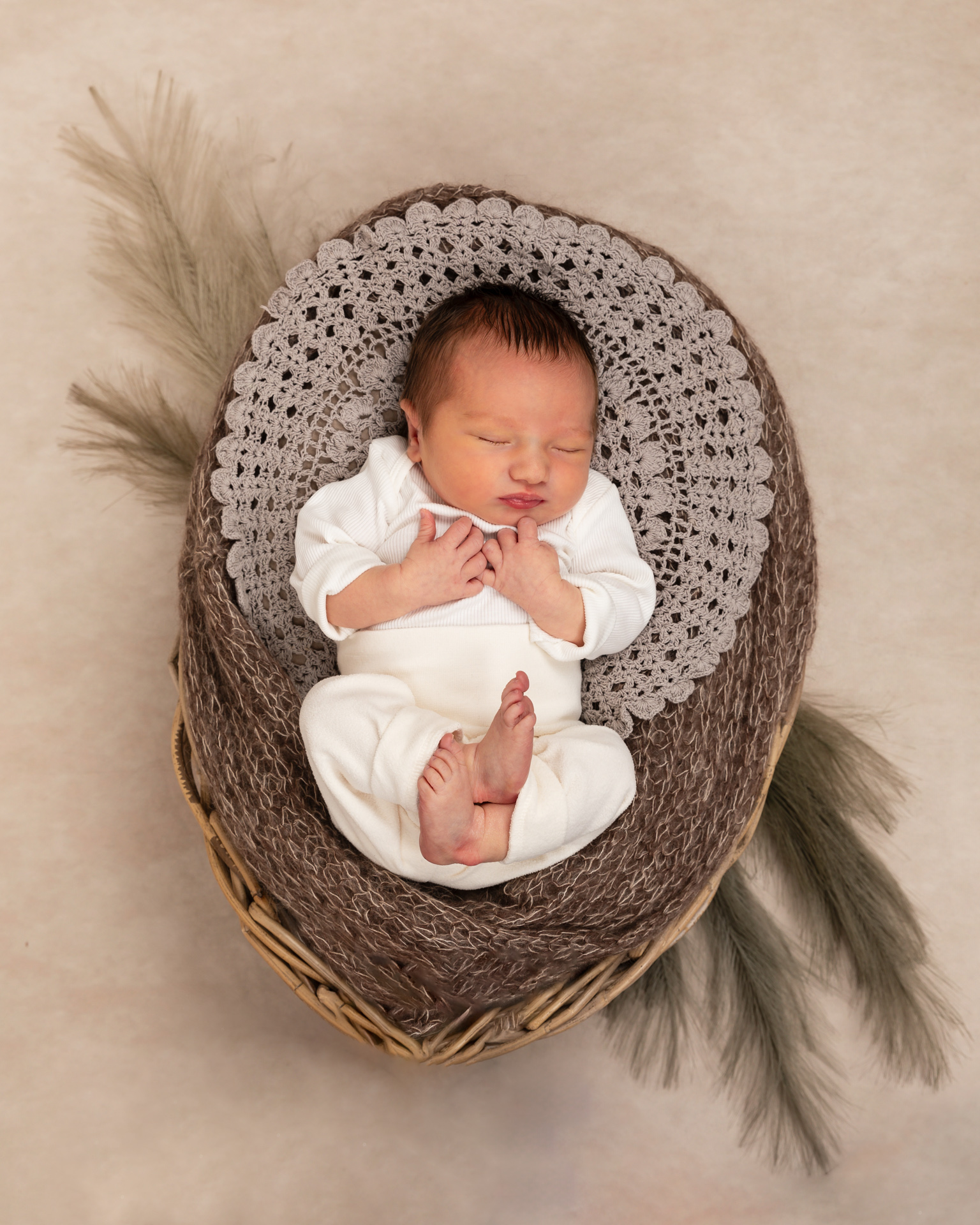 Schlafendes Neugeborenes im Holzkorb – Liebevolle Newborn-Fotografie im Fotostudio Rheintal