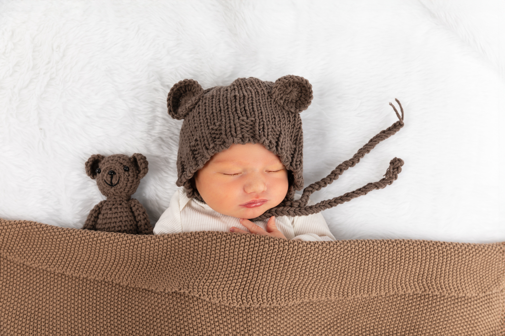 Neugeborenes mit süssem Mützchen und Blumenkranz – Babyfotoshooting Fotostudio Rheintal
