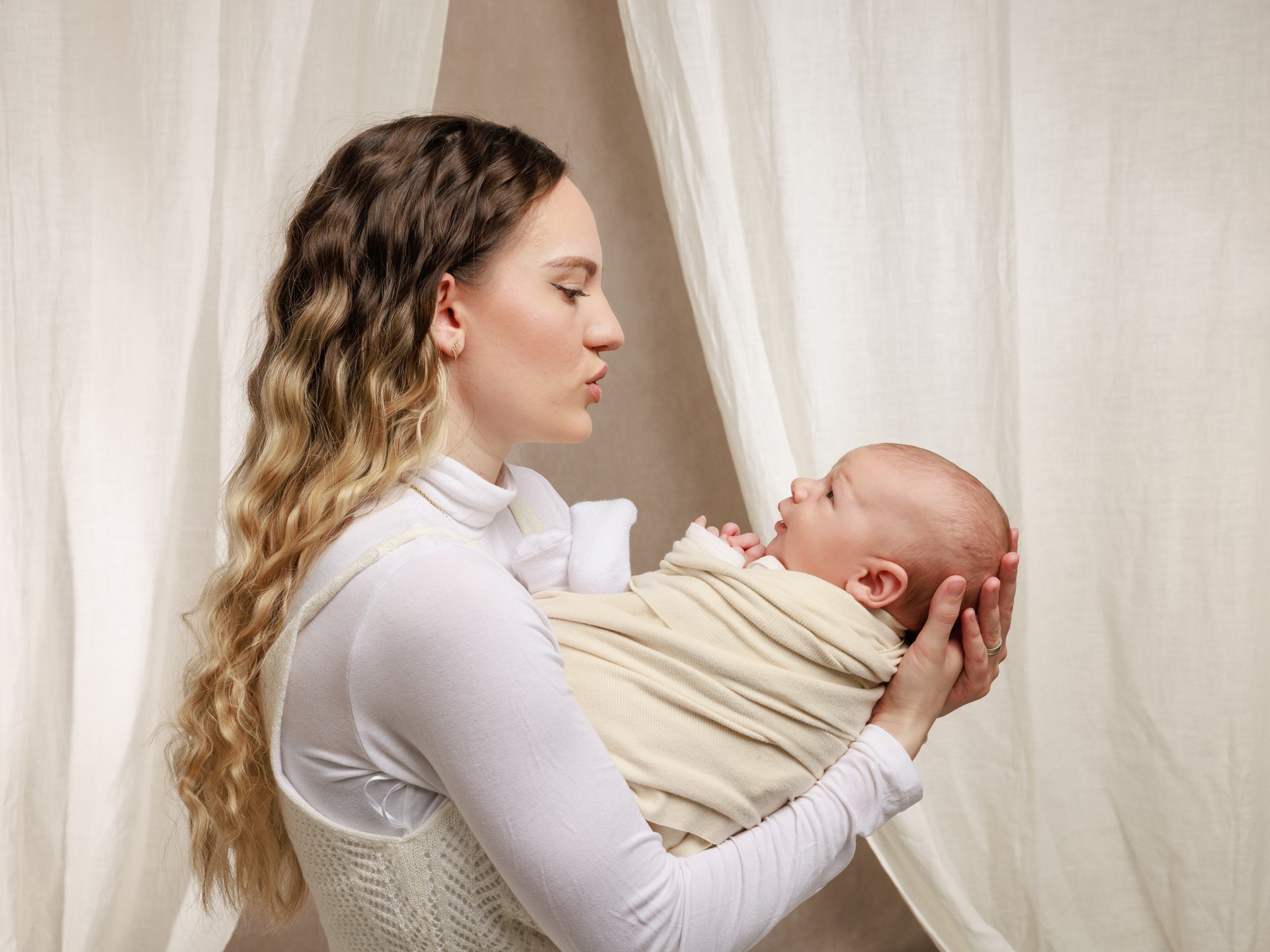 Liebevolles Kuschelfoto von Mama und Neugeborenem – Natürliche Babyfotografie Rebstein